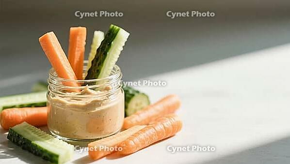 Carrot and cucumber sticks in a glass with dip on a white table in sunlight, delicious dip, perfect as a side dish for meals and parties, AI generates, AI generated [IBR124458908]
