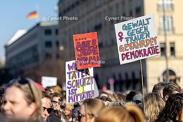 Berlin, Germany - 22.3.2026: Demonstrators, including one holding up a poster with the inscription: - Violence against woman endangers democracy - protesting in front of the Brandenburg Gate under the theme Demonstration against sexualized digital violenc [IBR113108128]