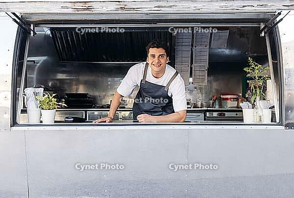 Portrait of a young food truck owner. Food truck owner waiting for customers [IBR124491545]