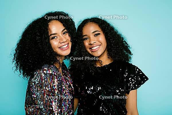 Smiling friends standing at blue background in studio [IBR124491570]