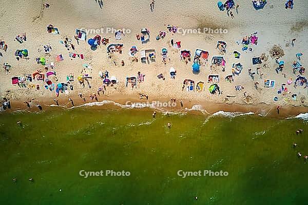 Aerial view of sea landscape with crowded sand beach in Wladyslawowo. Baltic sea coastline with swimming people in Poland. Resort town in summer season [IBR124497426]
