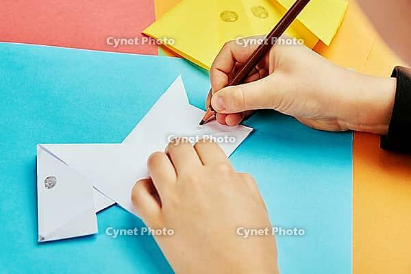 Boy hands making origami dog with colorful paper sheets, Child creative education [IBR124497438]