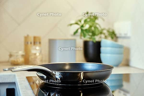 Steel frying pan in the kitchen on electric induction hob, Modern kitchen appliance [IBR124497441]