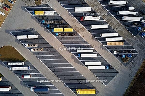 Top view of semi trucks waiting for loading at parking lot at logistic warehouse. Aerial view of highway lorry trailers on rest area [IBR124497445]