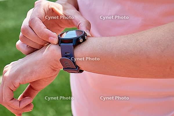 Woman use fitness watch before cardio exercises, Checking results on smart watch after training, Healthy lifestyle concept [IBR124497449]