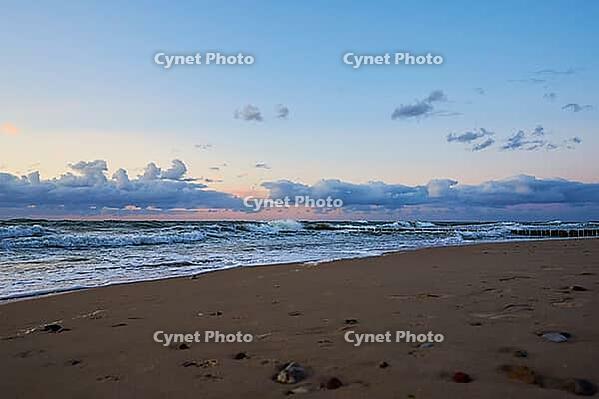 Sea coastline with waves. Baltic sea beach against dramatic cloudy sky at sunset. Panoramic nature landscape [IBR124497455]