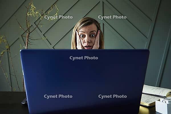 Shocked woman looking at laptop screen with rounding eyes. Excited emotional reaction at online news [IBR124497456]