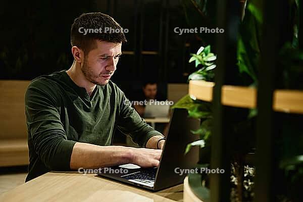 Male hands typing on laptop keyboard, close up. Man using laptop in office. Online work [IBR124497480]
