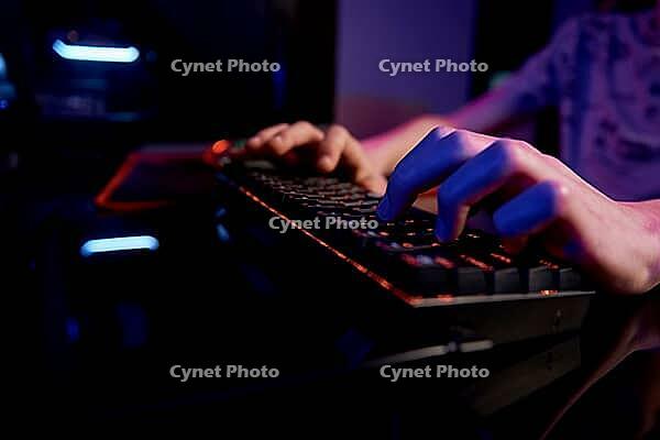Professional gamer play computer video game in dark room, use neon colored rgb mechanical keyboard, place for cybersport gaming [IBR124497483]