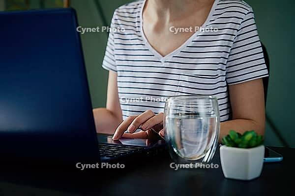 Caucasian woman typing with laptop keyboard at home office workplace. Freelancer remotely working [IBR124497487]
