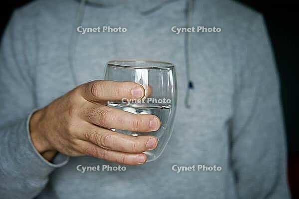 Man drinks water, Close-up shot of man holding glass of fresh water, Quenching thirst, Lifestyle healthcare concept [IBR124497490]