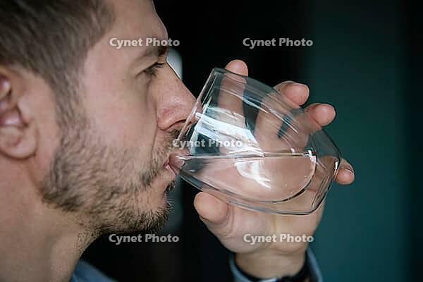 Man drinks water, Close-up shot of bearded man drinking fresh clean water from glass, Quenching thirst, Lifestyle healthcare concept [IBR124497492]