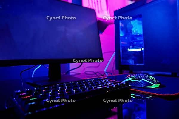 PC with rgb keyboard for gaming computer video games with neon colored background, dark room with game workplace without people [IBR124497495]