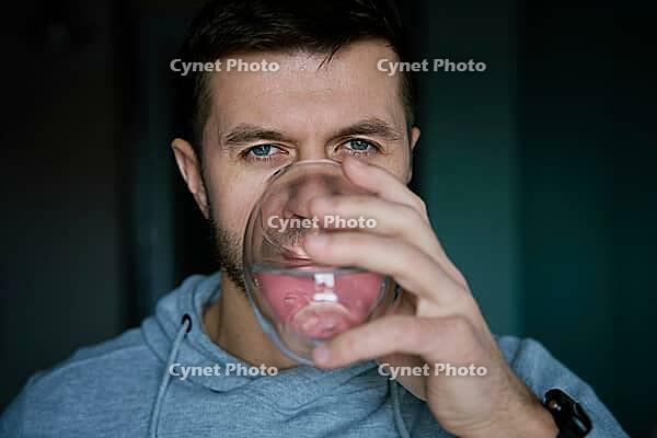 Man drinks water, Close-up shot of bearded man drinking fresh clean water from glass, Quenching thirst, Lifestyle healthcare concept [IBR124497497]