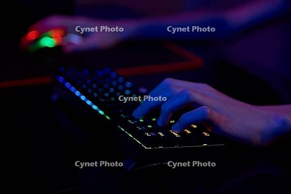 Professional gamer play computer video game in dark room, use neon colored rgb mechanical keyboard, place for cybersport gaming [IBR124497502]