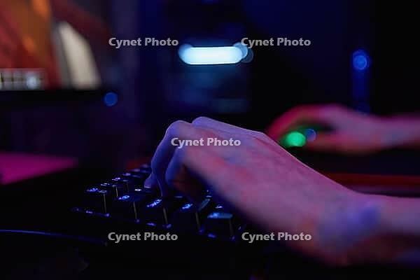Professional gamer play computer video game in dark room, use neon colored rgb mechanical keyboard, place for cybersport gaming [IBR124497504]