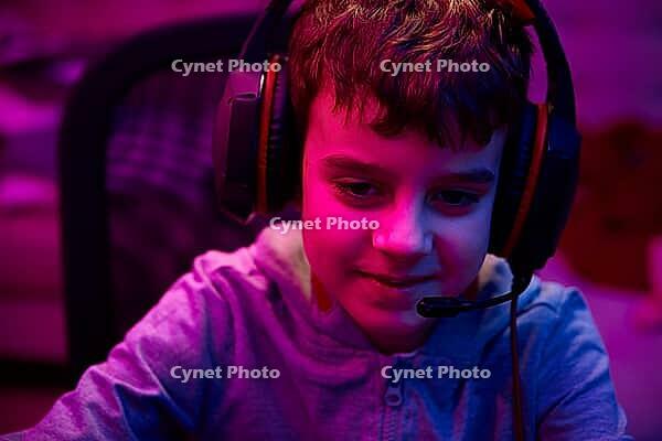 Portrait of boy playing computer video game in dark room, workplace for cybersport gaming, children gaming addiction [IBR124497506]