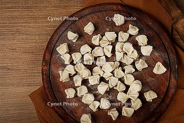 Traditional Turkish dumplings, raw, on a cutting board, top view, no people [IBR124552174]