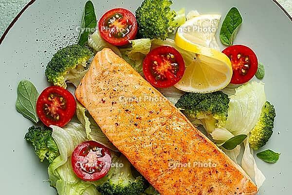 Grilled salmon fillet, with vegetables, broccoli, cherry, iceberg lettuce, spices and herbs, homemade, no people [IBR124552179]