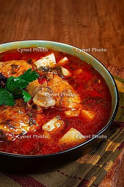 Souzi soup. Georgian dish, meat with oats, tomato sauce and herbs, on a wooden table [IBR124552182]