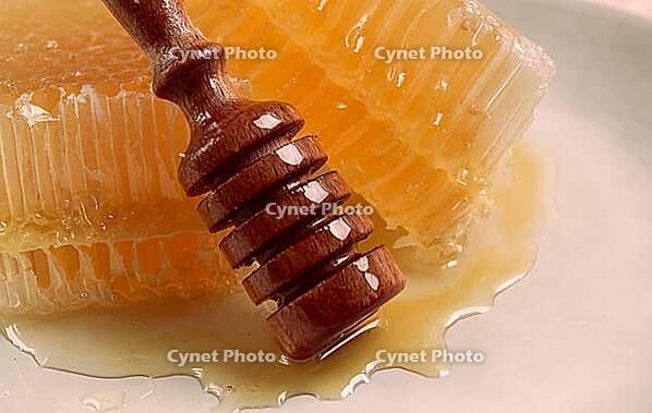 Honeycomb, with a wooden spoon-spindle, on a plate, no people [IBR124552187]