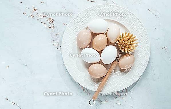The concept of health care, the fight against salmaniasis, washed chicken eggs, on a white plate, next to a washing brush [IBR124552211]