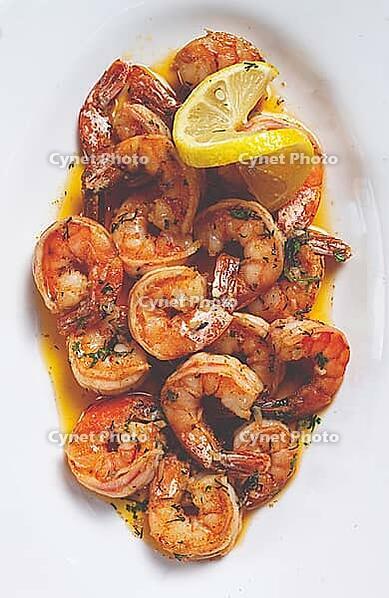 Fried tiger prawns, jumbo, in garlic sauce, in butter, with herbs, on a white plate, homemade, no people [IBR124552230]