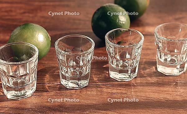 Empty shot glasses, shot glass, are on a wooden table, with lime, sunlight, no people [IBR124552237]