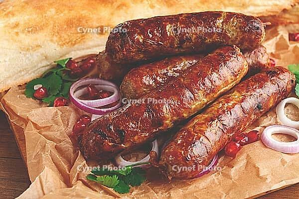 Fried kupaty on parchment, with red onion and pomegranate, kupaty, Georgian cuisine [IBR124552240]