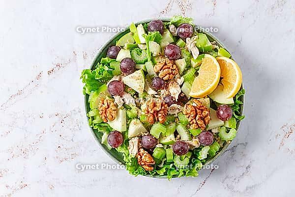 Fresh Waldorf salad, celery stalk with chicken, apple and walnuts, grapes, herbs, homemade, without people [IBR124552246]
