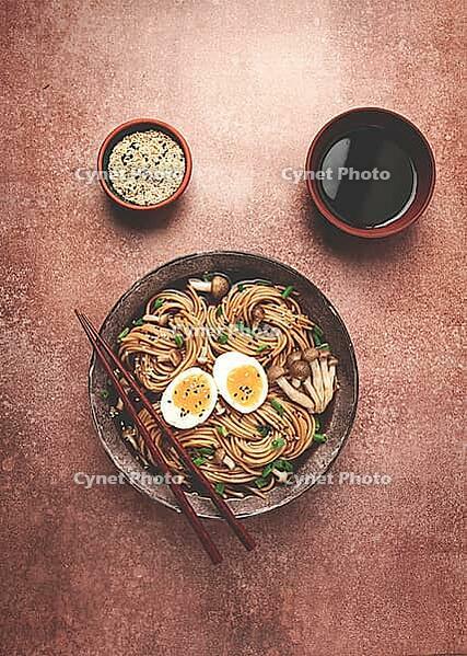 Buckwheat noodles, soba, with shimeji mushrooms, boiled egg, green onion, sesame seeds, homemade, no people [IBR124585363]