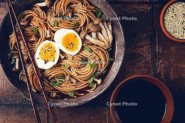 Buckwheat noodles, soba, with shimeji mushrooms, boiled egg, green onion, sesame seeds, homemade, no people [IBR124585367]