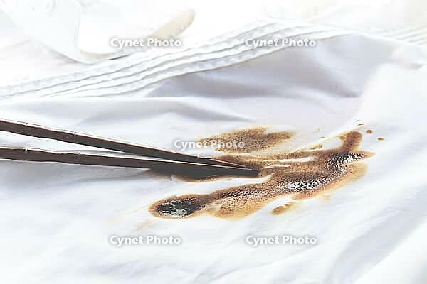 White shirt stained with soy sauce and chopsticks lying on it, no people, close-up, selective focus [IBR124585373]