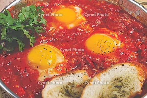 Shakshuka, breakfast, fried eggs in tomato sauce, with spices and herbs, homemade, no people [IBR124585377]