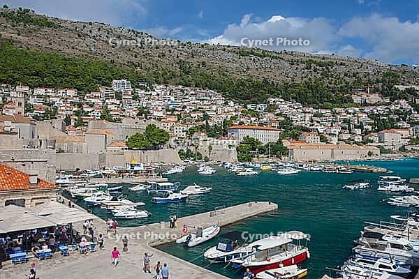 Dubrovnik, Croatia-12.09.2024: Panoramic view of Dubrovnik Old Harbor with white boats on the Adriatic Sea, surrounded by medieval city walls [IBR124586585]
