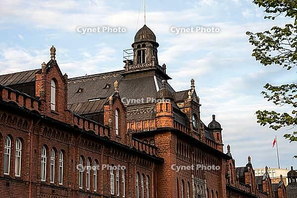 Helsinki, Finland - June 21, 2015 - Historic gothic architecture of red brick building with tower and ornaments under blue sky [IBR124626834]