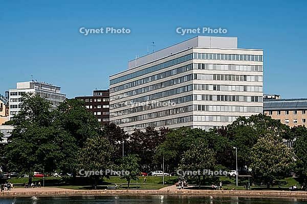 Helsinki, Finland - June 21, 2015 - Modern office building with park and people relaxing on a sunny day [IBR124626835]