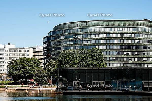 Helsinki, Finland - June 21, 2015 - Modern office building with glass facade by waterfront on sunny day [IBR124626837]