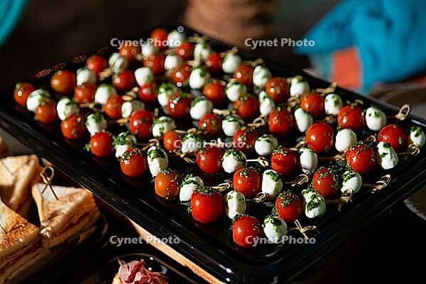 A vibrant arrangement of caprese skewers featuring juicy tomatoes, mini mozzarella balls, and fresh pesto. ideal for parties, these appetizers add color and flavor to any gathering [IBR124626859]