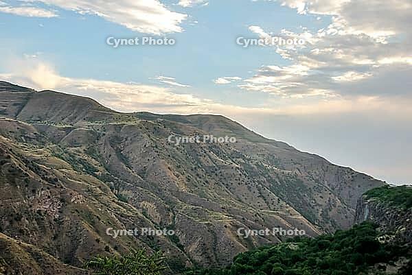 Scenic mountain range landscape under cloudy sky at sunset [IBR124626860]