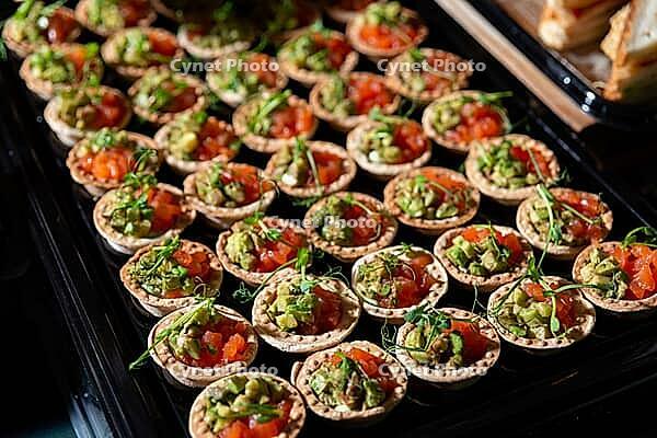 A vibrant display of tartlets filled with fresh vegetables and greens. perfect for parties, gatherings, or as a delightful snack option. ideal for food enthusiasts and culinary events [IBR124626865]