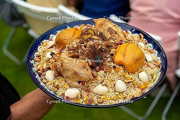 A vibrant middle eastern dish featuring roasted poultry, seasoned rice, nuts, and boiled eggs. this hearty meal is traditionally served during festive gatherings and cultural celebrations [IBR124626870]