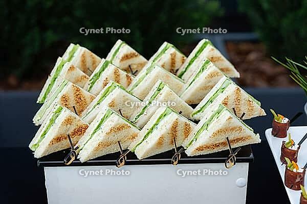 A neatly arranged platter of fresh garden sandwiches featuring green lettuce and creamy filling. perfect for party catering, this display essence of freshness and flavor [IBR124626888]