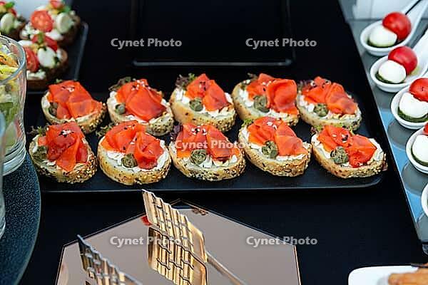 A selection of elegant canapés topped with smoked salmon, capers, and cream cheese. perfect for catering at events or sophisticated gatherings, offering a taste of luxury [IBR124626889]