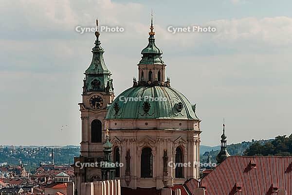 Prague, Czech - August 22, 2013 - St. nicholas church dome and clock tower in prague's skyline under blue sky [IBR124626900]