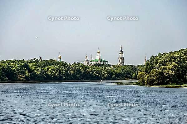 Kolomna, Russia - August 17, 2014 - Serene river with historic russian monastery surrounded by lush forest [IBR124626906]