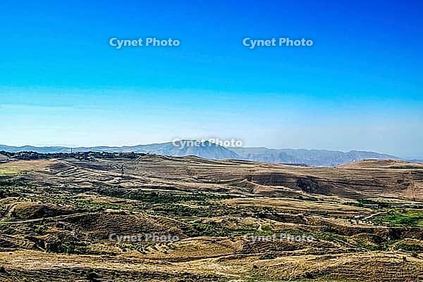 Expansive mountainous landscape with clear blue sky and rolling hills [IBR124626910]