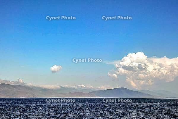 Tranquil mountainous horizon with open sea and expansive cloudy sky [IBR124626912]