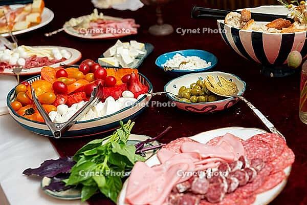 A vibrant spread featuring a variety of italian appetizers and antipasto. fresh vegetables, assorted meats, cheeses, and olives are artfully arranged to delight the senses [IBR124626913]