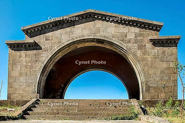 Ancient stone arch with inscriptions under clear blue sky [IBR124626924]